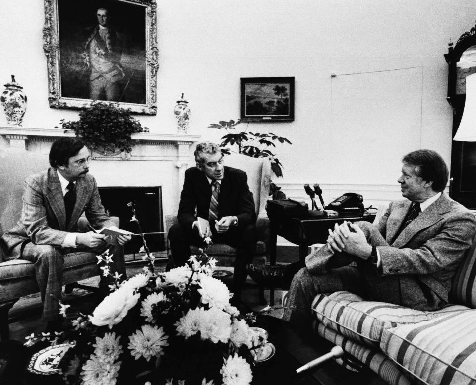 FILE - Washington Associated Press reporters Larry Knutson, left, and Frank Cormier interview President Jimmy Carter, right, at the White House, Jan. 25, 1977, in Washington Knutson, a longtime Associated Press writer whose deep knowledge of the presidency, Congress and American history made him an institution in his own right, has died Saturday, Dec. 16. 2023. He was 87. (AP Photo, File)