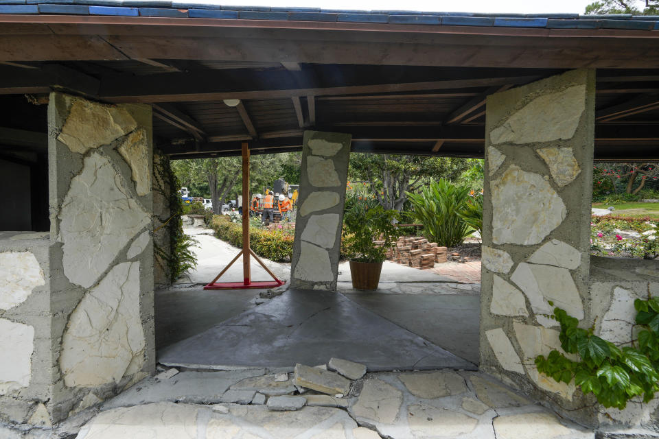 Wood beams support tilted hall walls next to the Wayfarers Chapel, known as "The Glass Church," in Rancho Palos Verdes, Calif., Wednesday, May 15, 2024. The modernist chapel features organic architecture with glass walls nested in a redwood grove overlooking the Pacific Ocean. The famed cliffside location on the Palos Verdes Peninsula is also responsible for its downfall. While the Portuguese Bend landslide began in 1956, it's recently worsened, and chapel officials say the earth underneath "The Glass Church" and its surrounding area is now moving an unprecedented 2 feet (0.61 meters) or more each month. (AP Photo/Damian Dovarganes)