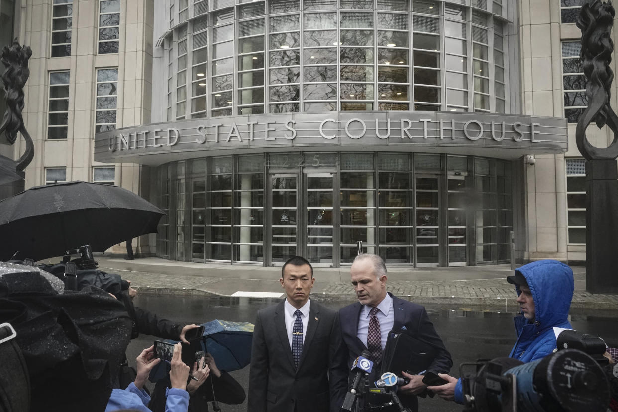 NYPD officer Baimadajie Angwang, center left, a naturalized U.S. citizen born in Tibet, and his attorney John Carman, center right, hold a press briefing outside Brooklyn's Federal court after a judge dismissed spy charges against him, Thursday Jan. 19, 2023, in New York. Federal prosecutors dropped charges against Angwang, who authorities had initially accused of spying on independence-minded Tibetans on behalf of the Chinese consulate in New York. (AP Photo/Bebeto Matthews)