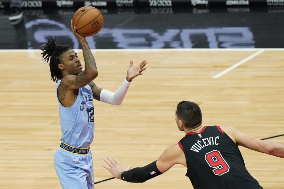 Memphis Grizzlies guard Ja Morant, left, shoots as Chicago Bulls center Nikola Vucevic defends during the first half of an NBA basketball game in Chicago, Friday, April 16, 2021. (AP Photo/Nam Y. Huh)