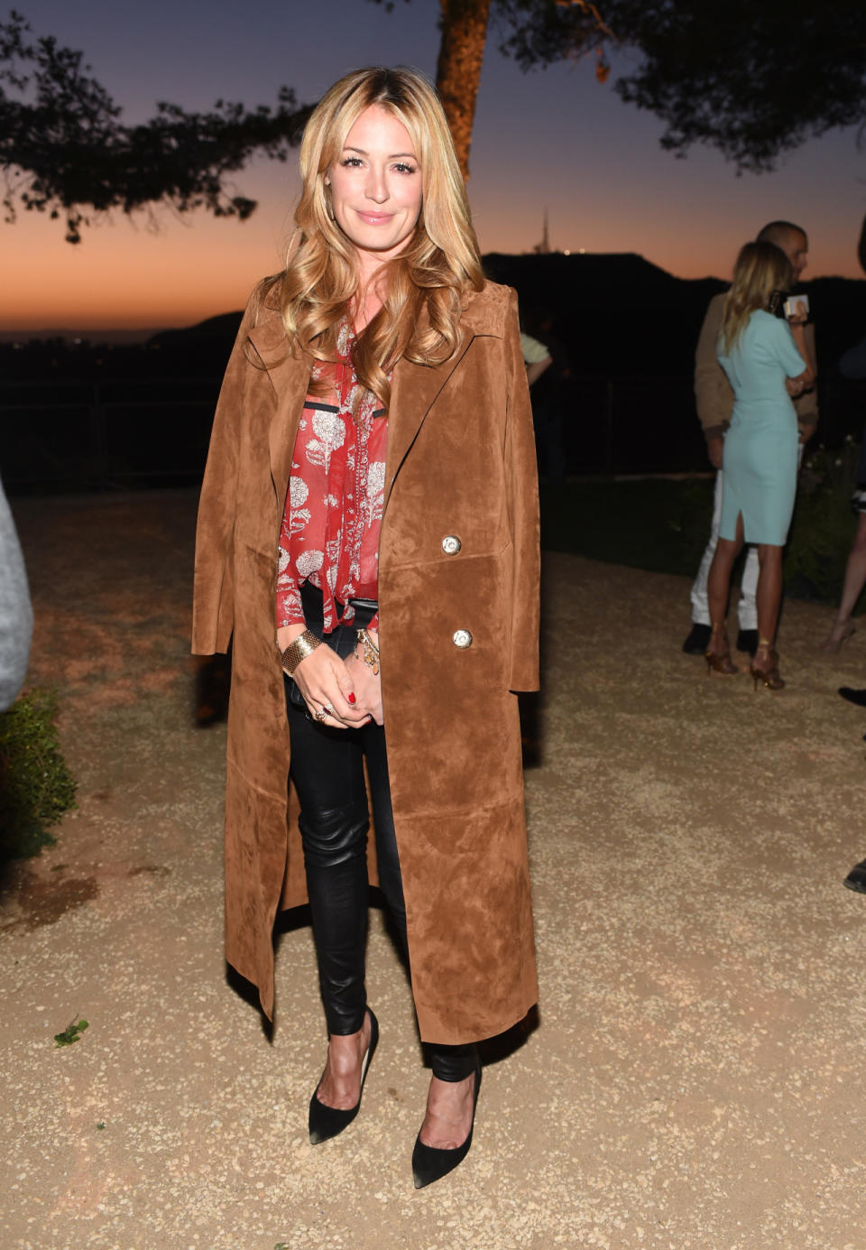 Temperatures might be warm in Los Angeles, but Cat Deeley, a Brit, has lived in the city long enough to know that they dip at night especially in the Hollywood Hills. She covered up and kept warm in leather pants, a floral blouse, and suede trench coat.