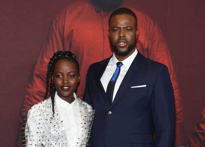 Lupita Nyong'o and Winston Duke posing together at a premiere