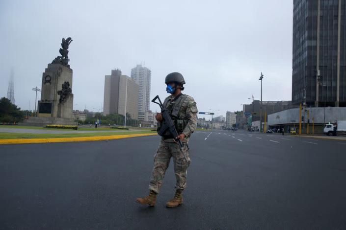 A soldier keeps watch after Peru's government deployed military personnel to block major roads, as the country rolled out a 15-day state of emergency to slow the spread of coronavirus disease (COVID-19), in Lima