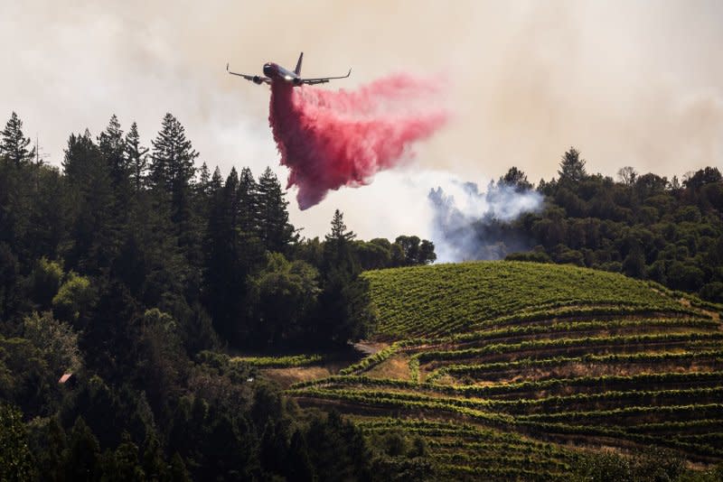 A plane drops retardant ahead of the Point Fire, west of Geyserville, Calif., on Sunday. Fast-moving wildfires, pushed by high winds, hit dry landscapes forcing evacuations as California enters the fire season. Photo by Peter DaSilva/UPI