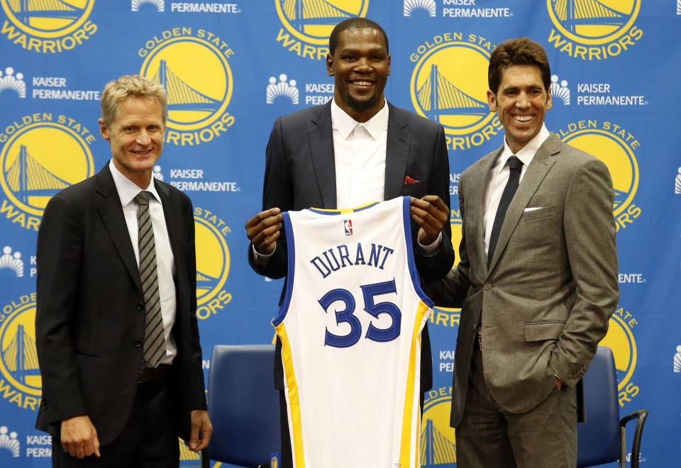 FILE - Golden State Warriors' newest player Kevin Durant, center, joins head coach Steve Kerr, left and general manager Bob Myers during a news conference at the NBA basketball team's practice facility, July 7, 2016, in Oakland, Calif. Durant decided to leave the Oklahoma City Thunder and join the Golden State Warriors. (AP Photo/Beck Diefenbach, File)