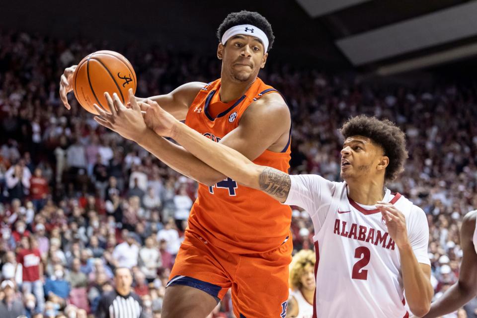 Auburn center Dylan Cardwell (44) and Alabama forward Darius Miles (2) chase a loose ball during the first half of an NCAA college basketball game, Tuesday, Jan. 11, 2022, in Tuscaloosa, Ala. (AP Photo/Vasha Hunt)