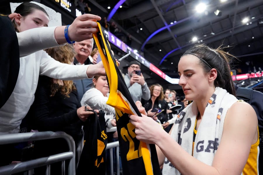 Iowa guard Caitlin Clark, right, signs autographs for fans after Iowa defeated Northwestern 110-74 in an NCAA college basketball game in Evanston, Ill., Wednesday, Jan. 31, 2024. (AP Photo/Nam Y. Huh)