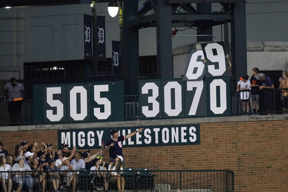 Fans watch as the Miggy Milestone sign changes after Detroit Tigers designated hitter Miguel Cabrera's single during the eighth inning of a baseball game against the Minnesota Twins, Saturday, July 23, 2022, in Detroit. (AP Photo/Carlos Osorio)