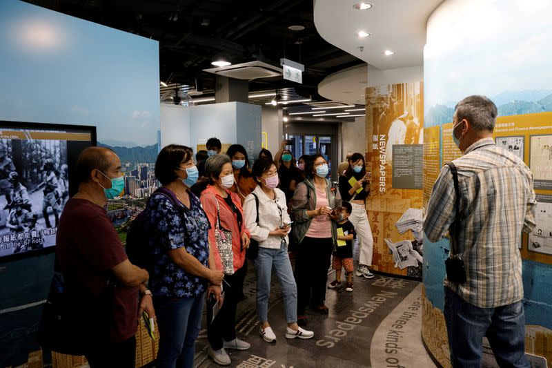 FILE PHOTO: Tourists wearing face masks listen to an instructor inside Hong Kong News-Expo during a Hong Kong Tourism Board's free local tour, following the coronavirus disease (COVID-19) outbreak, in Hong Kong