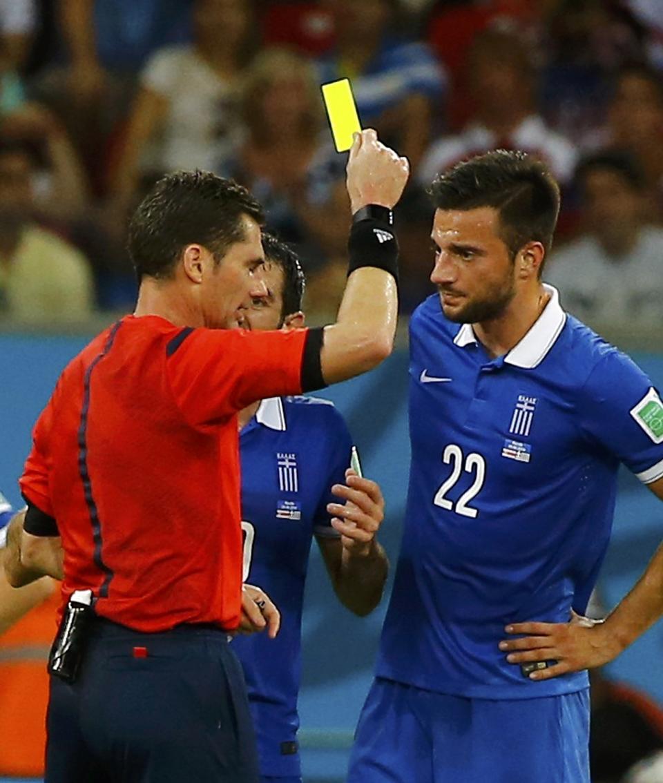 Referee Benjamin Williams of Australia shows the yellow card to Greece's Andreas Samaris (R) during their 2014 World Cup round of 16 game against Costa Rica at the Pernambuco arena in Recife June 29, 2014. REUTERS/Damir Sagolj