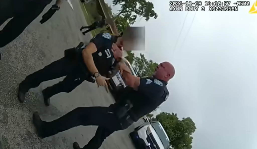 The video shows police officer Christopher Pullease turning around and grabbing the young officer by her throat with one hand, while holding the pepper spray with another (Screengrab: YouTube/ WPLG Local 10)