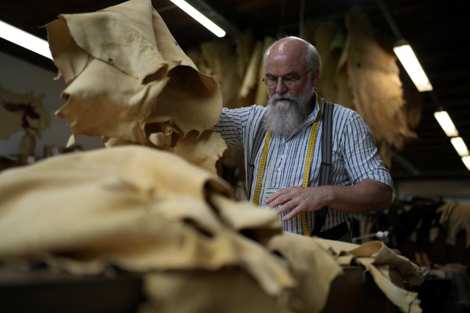 Saddler Klaus Bensmann works in his store in Bad Hindelang, Germany, Wednesday, Sept. 13, 2023. Bensmann produces tailored leather trousers and vests with hand embroidery. The leather comes from the alpine region and is tanned in Germany. For the upcoming Oktoberfest, many visitors like to wear the traditional dress. The 189th Oktoberfest, the world's biggest beer festival, runs from Sept. 16 through Oct. 3, 2023.(AP Photo/Matthias Schrader)