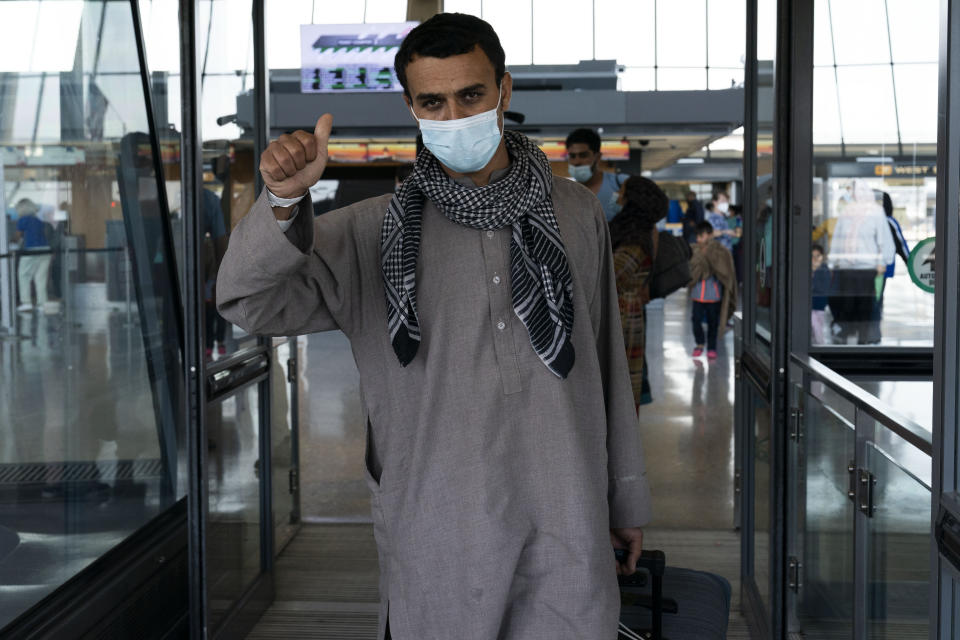 Families evacuated from Kabul, Afghanistan, walk through the terminal before boarding a bus after they arrived at Washington Dulles International Airport, in Chantilly, Va., on Friday, Aug. 27, 2021. (AP Photo/Jose Luis Magana)