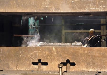 An employee works with a titanium ingot at the VSMPO-Avisma factory in Verkhnyaya-Salda, some 1,800 km (1,100 miles) east of Moscow, in this November 7, 2013 file photo. REUTERS/Svetlana Burmistrova/Files