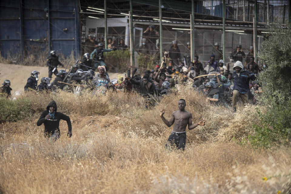 Migrants run on Spanish soil after crossing the fences separating the Spanish enclave of Melilla from Morocco in Melilla, Spain, Friday, June 24, 2022. Dozens of migrants stormed the border crossing between Morocco and the Spanish enclave city of Melilla on Friday in what is the first such incursion since Spain and Morocco mended diplomatic relations last month. (AP Photo/Javier Bernardo)