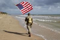 <p>A man dressed with U.S. 101st Airborne Division military uniforms walks on the beach during commemorations marking the 73th anniversary of D-Day. Many people gather On June 6 each year in Normandy to mark the anniversary of World War II’s D-Day landing. (Photo: Chesnot/Getty Images) </p>