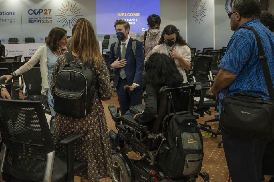 Jason Boberg, center, a member of the disability caucus and a founder of the disability climate action network SustainedAbility, speaks with disabled persons after a panel discussion, during the COP27 U.N. Climate Summit, in Sharm el-Sheikh, Egypt, Wednesday, Nov. 9, 2022. (AP Photo/Nariman El-Mofty)