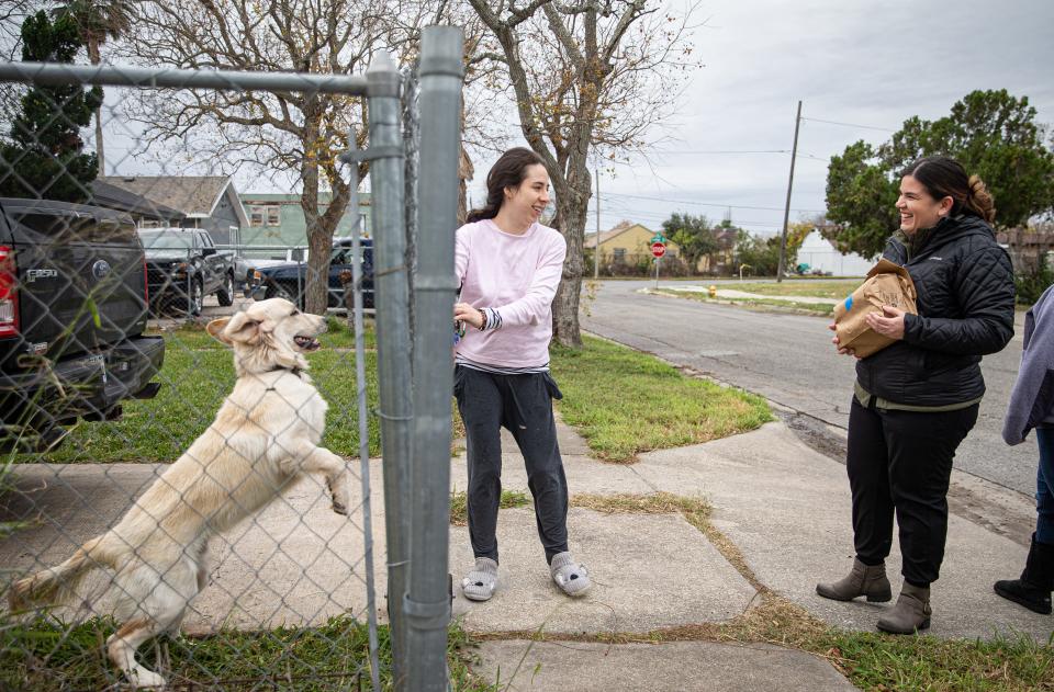 Fish for Life volunteer and Allen Elementary Principal Jennifer Perez delivers donated venison to Diana Crespo on Saturday, Jan. 22, 2022, in Corpus Christi. Crespo's dog, Max, jumps around excitedly.