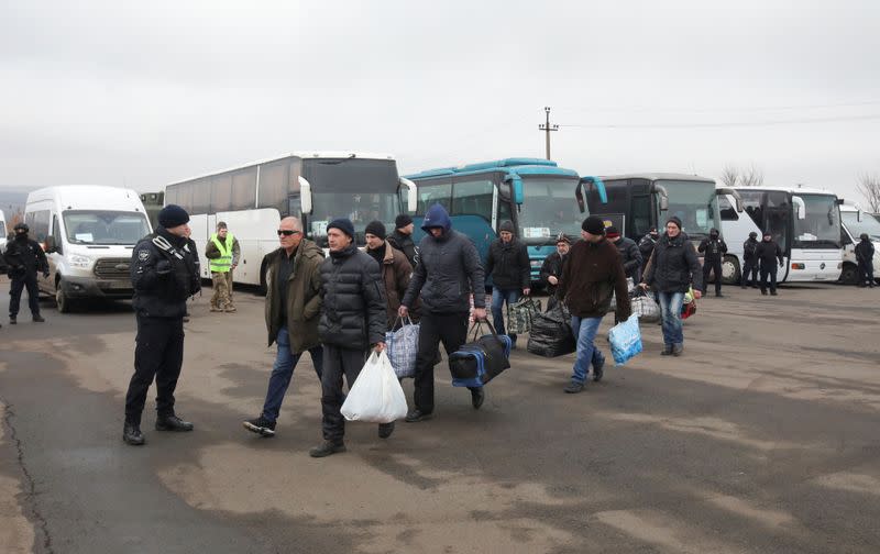 Men get off buses during prisoner of war exchange between Ukraine and the separatist republics in Donetsk region