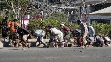 People seek shelter during a gunfire at an army base in Yemen's southern port city of Aden March 25, 2015. REUTERS/Anees Mansour