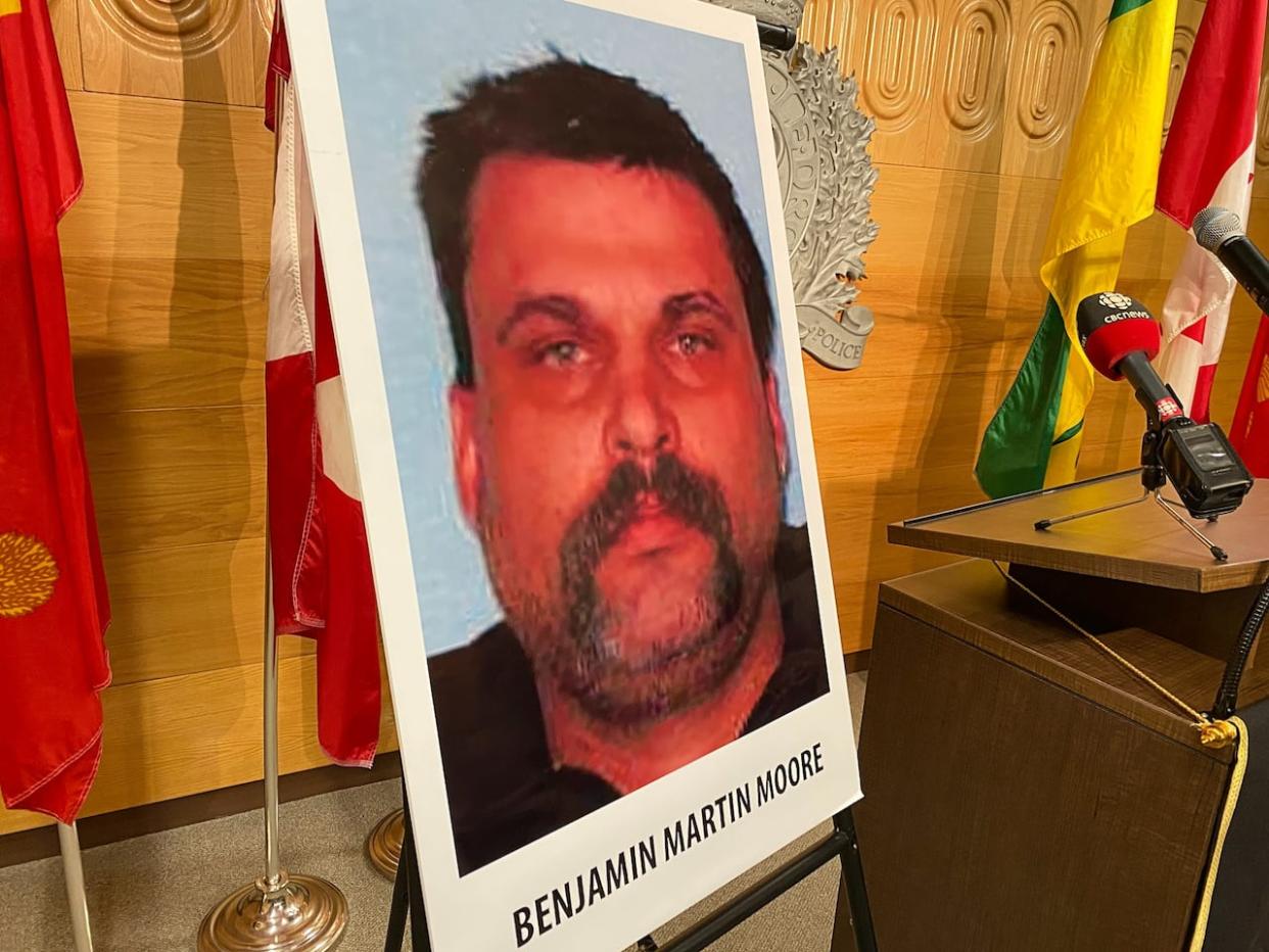 A photo of Benjamin Martin Moore is shown at an RCMP news conference in Regina on Tuesday, Aug. 9, 2022. Moore was later apprehended in South Dakota through multi-agency co-operation, according to U.S. Customs and Border Protection. (Adam Hunter/CBC - image credit)