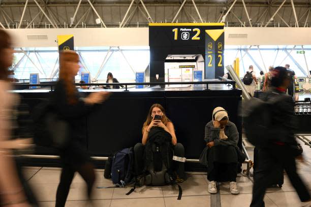 Passengers wait at Gatwick Airport, south of London, on 29 August 2023 (AFP via Getty Images)