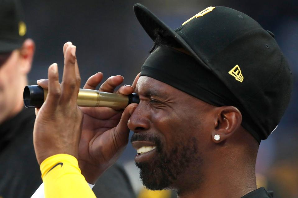 Pirates designated hitter Andrew McCutchen uses a spy glass in the dugout against the Tigers during the fourth inning on Monday, April 8, 2024, in Pittsburgh.
