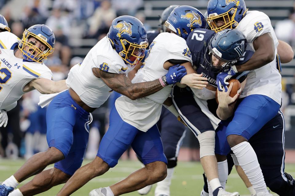 Villanova quarterback Daniel Smith is surrounded by the South Dakota State defense in the first quarter of an FCS quarterfinal NCAA college football game on Saturday, Dec. 11, 2021, in Villanova, Pa.  (Elizabeth Robertson/The Philadelphia Inquirer via AP)