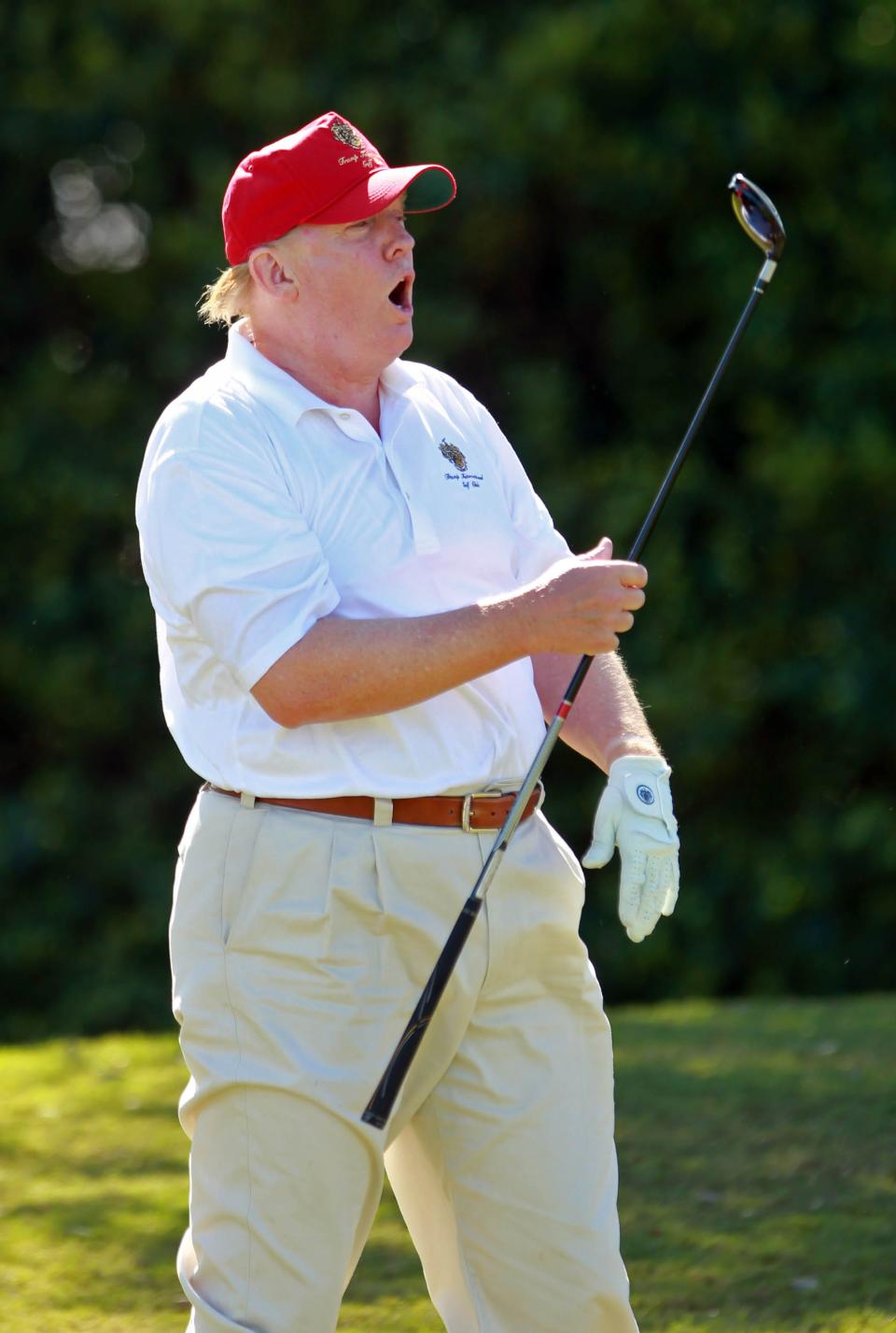 Former president Donald Trump reacts to a shot during a round of golf.