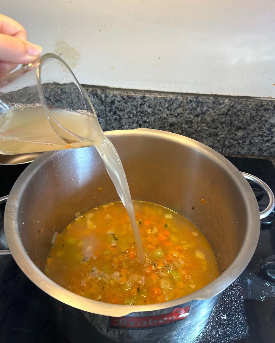 Adding chicken broth for Ina Garten's winter minestrone soup
