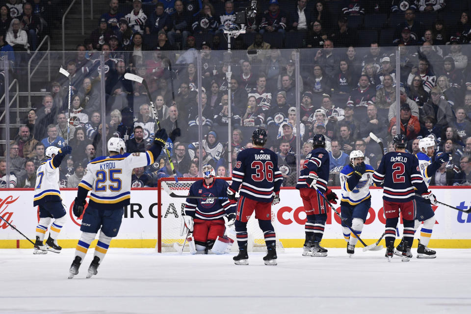 St. Louis Blues' Pavel Buchnevich, right, celebrates his goal on Winnipeg Jets goaltender Connor Hellebuyck during the second period of an NHL hockey game Tuesday, Oct. 24. 2023, in Winnipeg, Manitoba. (Fred Greenslade/The Canadian Press via AP)