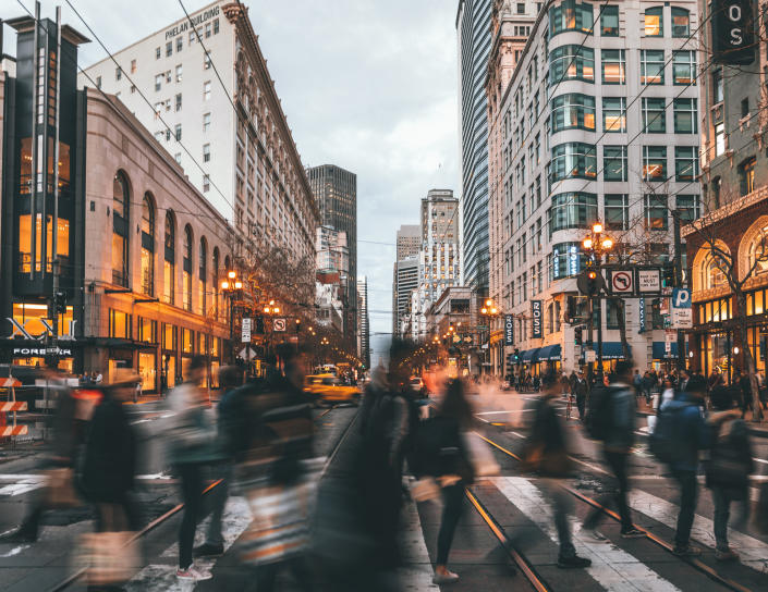 blurry photo of people on a crosswalk in the city