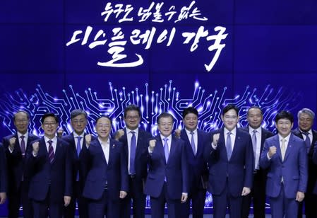 South Korean President Moon Jae-in and Samsung Electronics Vice Chairman, Jay Y. Lee pose for a group photo after a signing ceremony at Samsung Display's factory in Asan