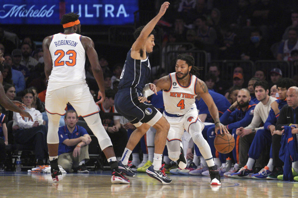 New York Knicks guard Derrick Rose, right, drives around Dallas Mavericks guard Josh Green, center, during the first quarter of an NBA basketball game, Saturday, Dec. 3, 2022, in New York. (AP Photo/Bebeto Matthews)