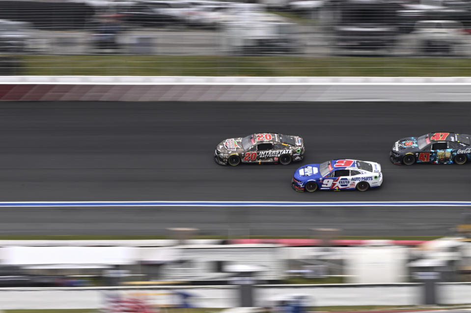Christopher Bell (20), Chase Elliott (9) and Ricky Stenhouse Jr. (47) steer through Turn 3 during a NASCAR Cup Series auto race at Charlotte Motor Speedway, Monday, May 29, 2023, in Concord, N.C. (AP Photo/Matt Kelley)