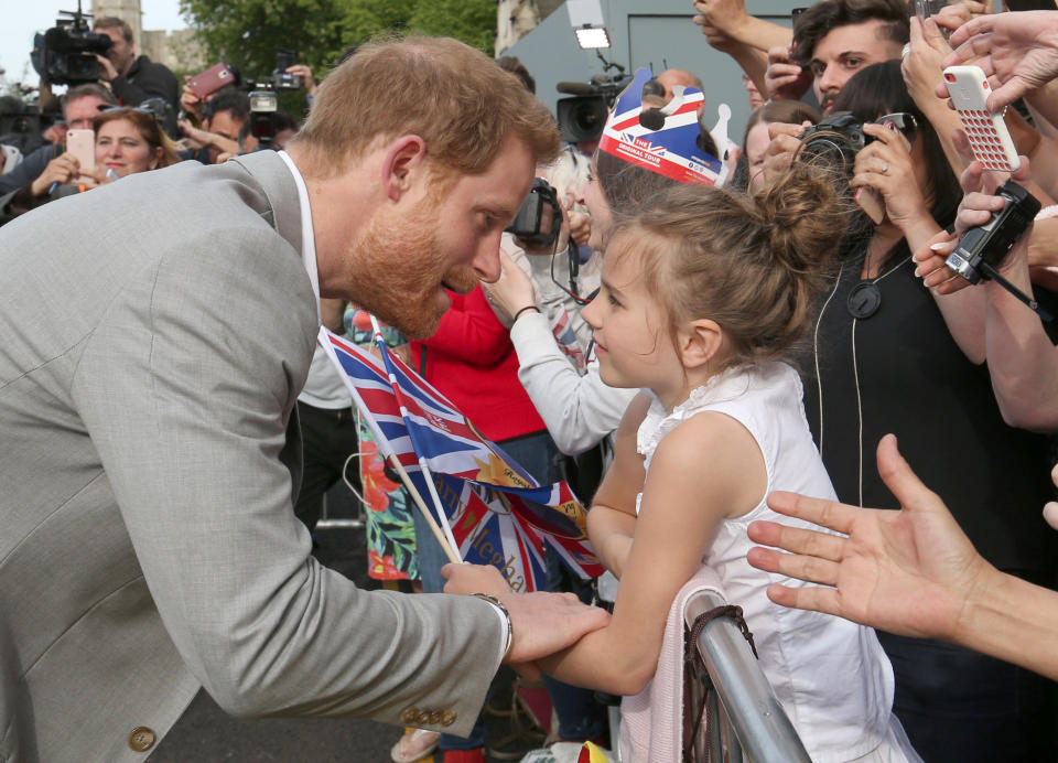 Prince Harry talks with a young girl during a walkabout in Windsor ahead of his wedding to Meghan Markle. Photo: Ben Birchall/pool via Reuters)