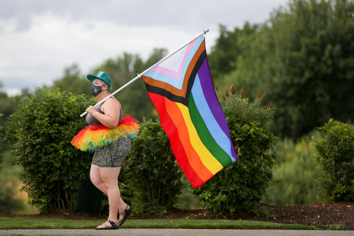 Aimee Fritsch holds a flag in support of the LGBTQ+ community and attends Capital Pride at Riverfront Park on Saturday, Aug. 21, 2021, in Salem, Ore. Pride in the Park starts at 10 a.m. on Saturday at Riverfront Park.