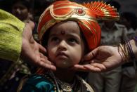 <p>Die traditionelle Aufmachung eines Mädchens wird von zwei Erwachsenen begutachtet. Das Hindu-Fest Gudi Padwa, bei dem Neujahr, Erntedank und Frühlingsanfang in einem gefeiert werden, ist für die rund 115 Millionen Einwohner des Bundesstaates Maharashtra das wichtigste Fest des Jahres. (Bild: Divyakant Solanki/EPA) </p>