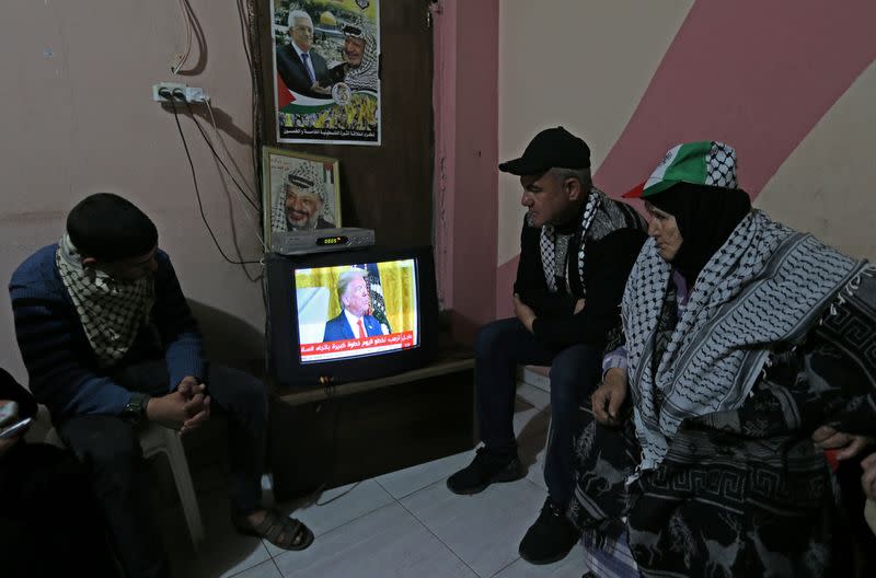 Palestinians watch a television broadcasting the announcement of Mideast peace plan by U.S. President Donald Trump, in the southern Gaza Strip