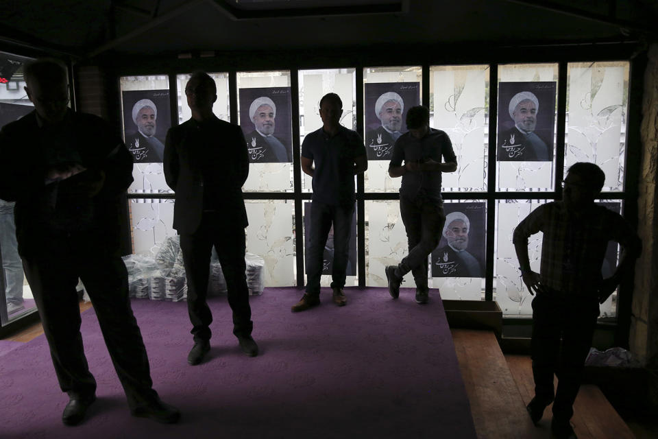 <p>Watchers are silhouetted while following TV debate of Iranian presidential candidates of May 19 elections, in one of electoral campaign offices of President Hassan Rouhani, shown in posters in background, in northern Tehran, Iran, May, 5, 2017. (Photo: Vahid Salemi/AP) </p>