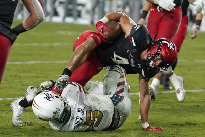 Cincinnati running back Ethan Wright (4) runs over South Florida linebacker Antonio Grier Jr., for a touchdown during the second half of an NCAA college football game Friday, Nov. 12, 2021, in Tampa, Fla. (AP Photo/Chris O'Meara)
