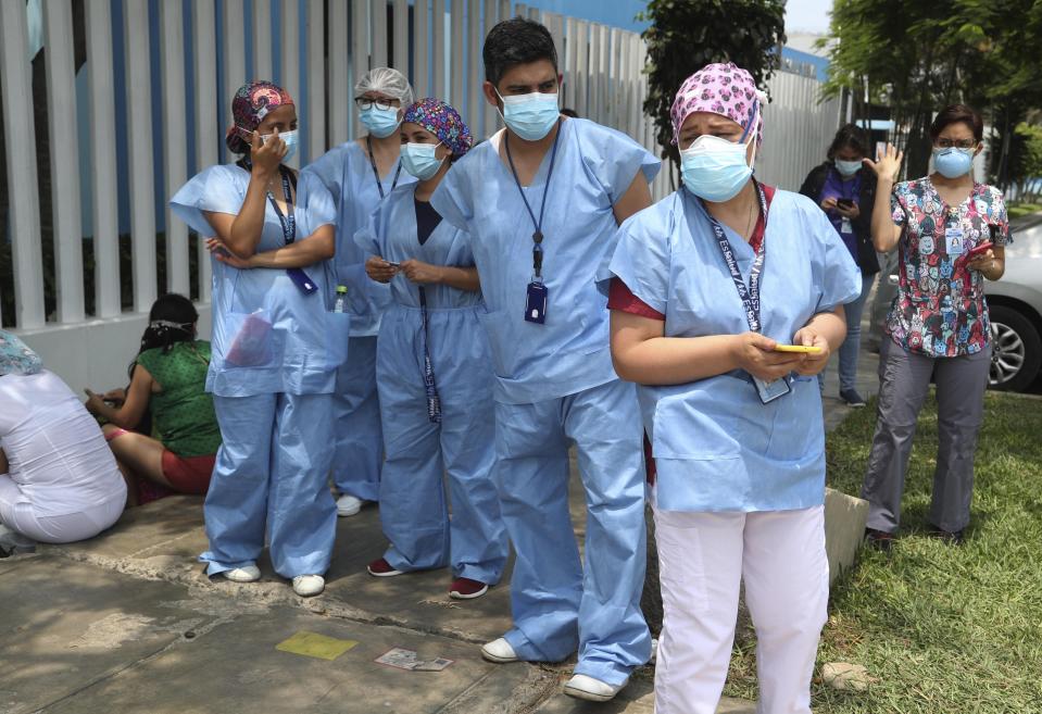 Medical workers who say they work directly with COVID-19 patients stand outside the public Rebagliati Hospital where they say they work, as other health workers get shots of China's Sinopharm vaccine during a priority vaccination campaign inside the facility in Lima, Peru, Wednesday, Feb. 10, 2021. The group complains they are not on the list of medical workers to be vaccinated and that some people getting shots do not work directly with COVID-19 patients. (AP Photo/Martin Mejia)
