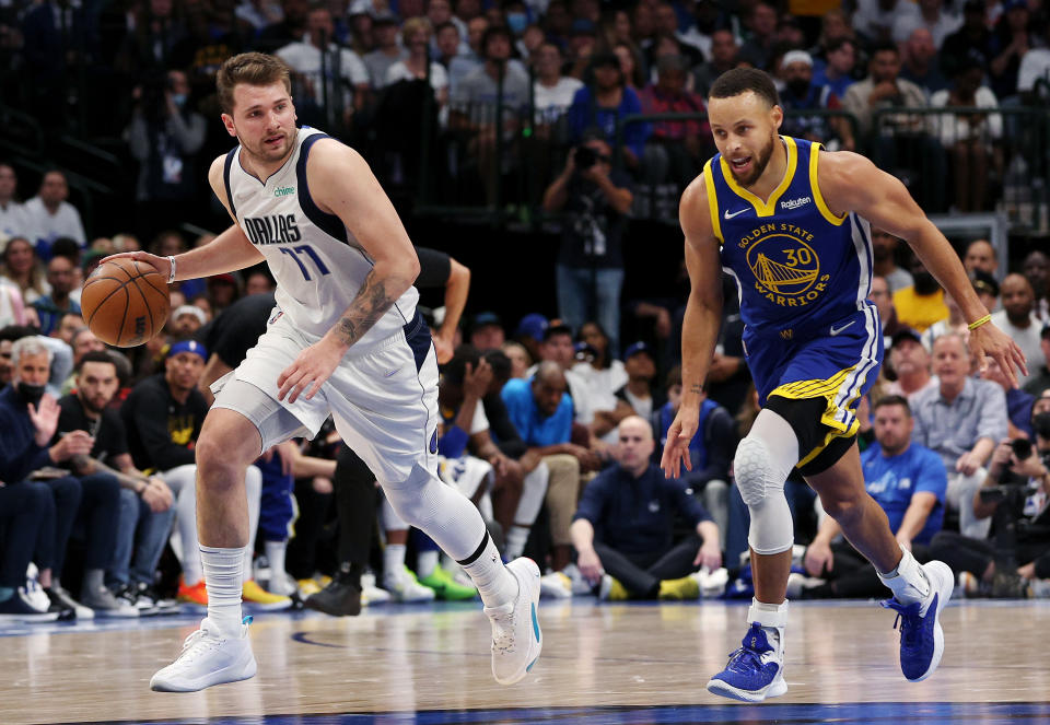 Dallas Mavericks guard Luka Doncic brings the ball up court against Golden State Warriors guard Stephen Curry in Game 4 of the Western Conference finals at American Airlines Center in Dallas on May 24, 2022. (Tom Pennington/Getty Images)