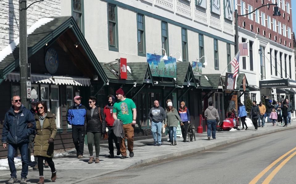 People enjoy a sunny day along Main Street in downtown Lake Placid April 7, 2024. Many are in town for the solar eclipse on Monday.