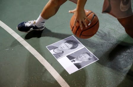 A protester dribbles a basketball over pictures of China's President Xi and Hong Kong Chief Executive Carrie Lam during gathering in support of NBA's Houston Rockets' team general manager Daryl Morey, who sent a tweet backing the pro-democracy movement