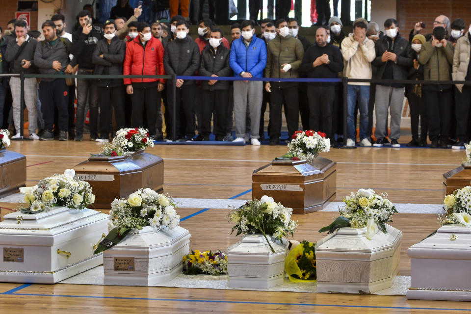 FILE - This March 1, 2023 file photo shows survivors and relatives of the victims praying inside the PalaMilone sports center in Crotone, southern Italy, for the migrants who died after their boat capsized in the early morning of Sunday, Feb. 26, 2023, at a short distance from the shore in Steccato di Cutro, in the Italian southern tip, killing at least 94 people. Survivors and family members of the victims are converging in the area for a commemoration on Monday, Feb. 26, 2024, on the first anniversary of the disaster. (AP Photo/Giuseppe Pipita)