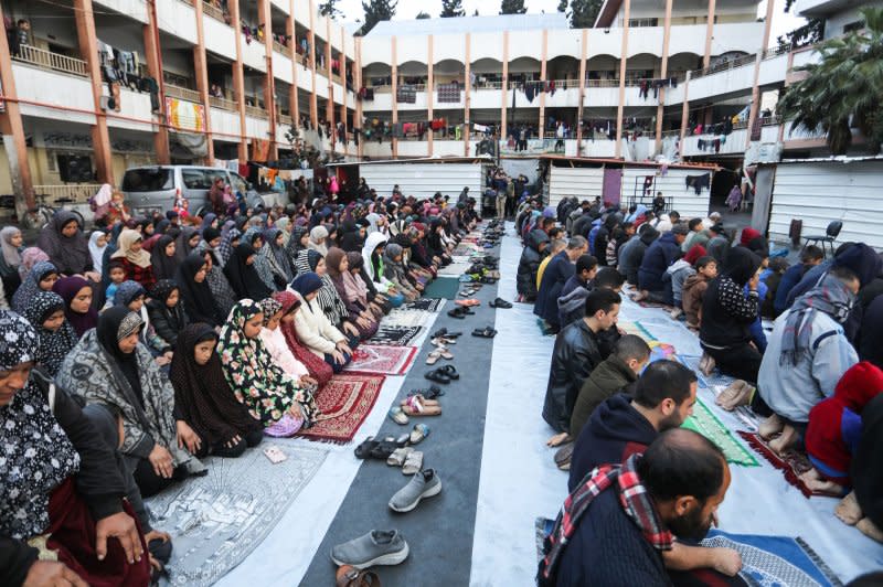 Displaced Palestinians attend a special morning prayer Wednesday for the Eid al-Fitr festival, marking the end of the holy month of Ramadan, at a school-turned-shelter in Rafah, in the southern Gaza Strip. The holiday comes amid the ongoing conflict between Israel and Palestinian militants. Photo by Ismael Mohamad/UPI