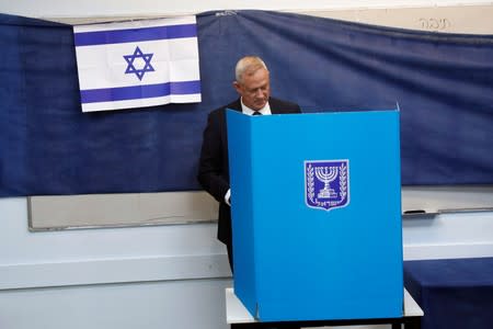 Leader of Blue and White party, Benny Gantz stands behind a voting booth as he votes in Israel's parliamentary election at a polling station in Rosh Ha'ayin, Israel