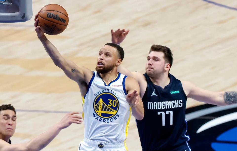 Steph Curry shoots past the Mavericks' Luka Doncic.