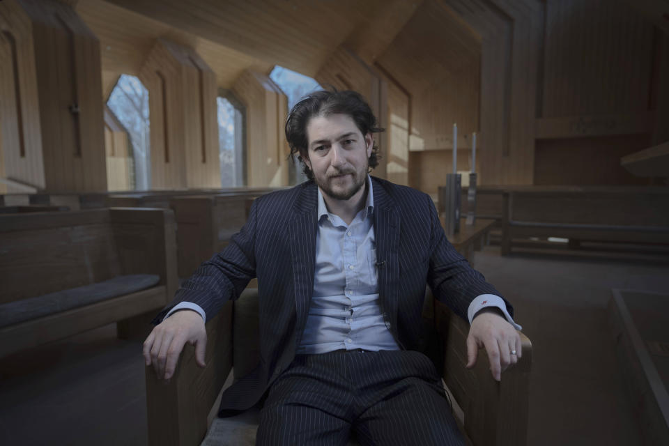 Rabbi Joshua Franklin poses for a portrait inside the sanctuary at the Jewish Center of the Hamptons in East Hampton, New York on Feb. 10, 2023. Franklin experimented with using the artificial intelligence program Chat GPT to write a sermon, asking members of his congregation whether they could identify who wrote the text. (AP Photo/Robert Bumsted)